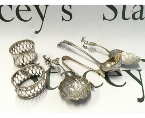Two Continental silver tea caddy type spoons, a pair of napkin rings , tongs