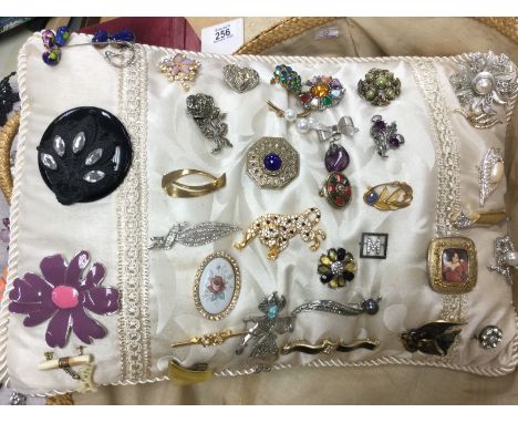 A collection of various vintage brooches. Postage cat B