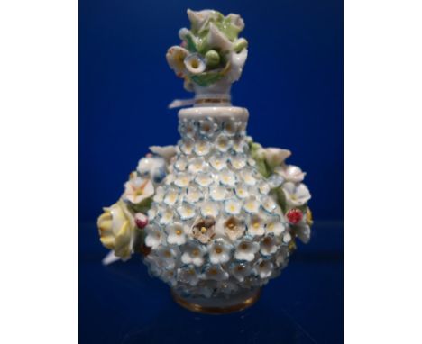 A CONTINENTAL CERAMIC PERFUME BOTTLE, encrusted with flowers, 9.5cm high