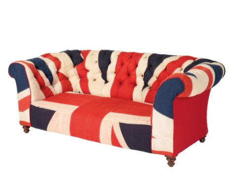 A VICTORIAN TWO-SEATER CHESTERFIELD SOFA, later upholstered with the Union Jack flag, buttoned-back, raised on turned wooden 