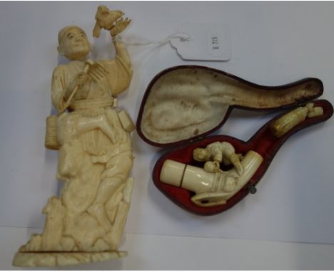 A JAPANESE CARVED IVORY STUDY of an old man and a cased pipe (2)