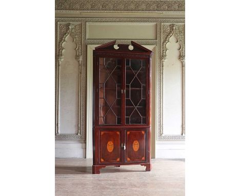 A George III-style mahogany standing corner cupboard,19th century, with a triangular break-arch pediment, above two geometric