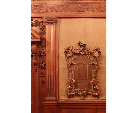 A giltwood mirror of Chippendale style,in the manner of Thomas Johnson, with an arched divided plate in shaped mirror borders