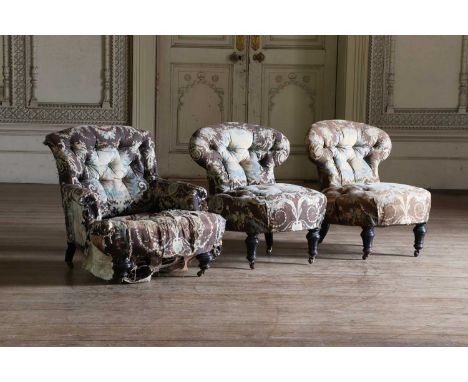 A pair of low occasional chairs,mid-Victorian, each button-upholstered with a waisted back, on ebonised turned legs and casto