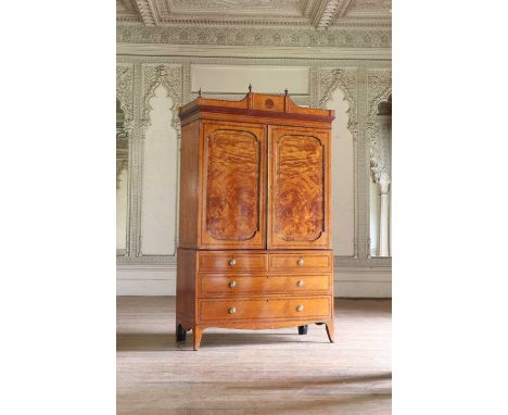 A satinwood press,late 19th century, with an architectural pediment, urn finials, and two panelled doors enclosing slides, ab