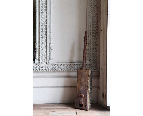 A three-stringed instrument,c.1900, Moroccan, with a hide cover and beaded fabric soundbox,21cm wide110cm long15cm deepCondit
