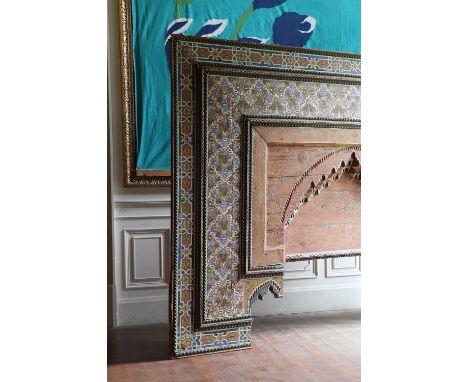 A massive carved and painted overdoor or arch,Indian, profusely painted and with a carved blockwork arch, 243cm wide 36cm dee