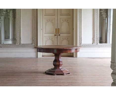 A large circular walnut extending dining table,early 20th century, French, the quarter-veneered top raised on a split-pedesta