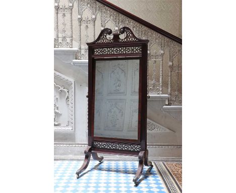 A George III Chippendale-style cheval mirror,the break-arch pediment carved and pierced with two rosettes, the rectangular mi