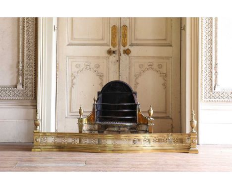 An Adam Revival brass and steel serpentine fire grate,  with pierced borders, urn finials and on square reeded supports, 82cm