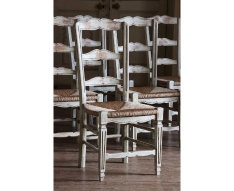 A set of eight painted ladder-back dining chairs,20th century, each with a rush seat, raised on square tapering fluted legs, 