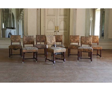 A set of eight Victorian stained oak side chairs,each with a close-nailed machine tapestry rectangular back and seat, on spir