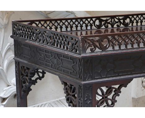 An Edwardian mahogany silver table,with a fret-carved gallery and blind-fret decoration to the frame, and husk-carved legs wi