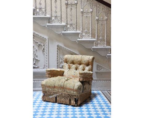 A Victorian library armchair,with button-upholstered back and arms, raised on square tapering supports, terminating on brass 