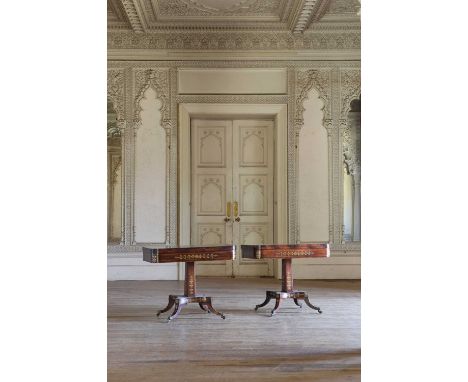 A pair of Regency rosewood and brass-inlaid pedestal card tables,each with a blue baize lining, on hipped and swept legs with