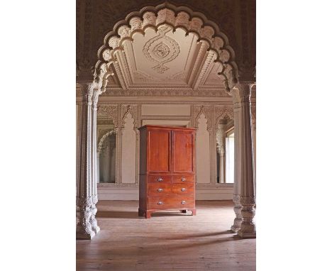 A George III mahogany linen press,the upper section with a Greek key moulded cornice and slides, enclosed by panel doors over