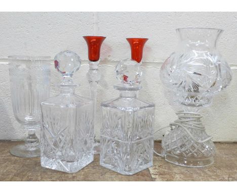 A glass table lamp, two glass decanters, a glass celery vase and a pair of glass candle holders with red tops