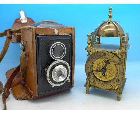 A Smiths brass lantern clock and an Aiglon TLR camera in a leather case