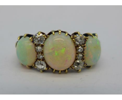 A Victorian 18ct gold three stone opal and eight stone diamond ring, 4.2g, N