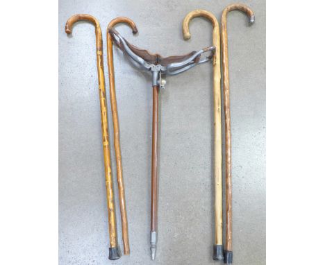 A shooting stick and four walking sticks, one with silver embellishment