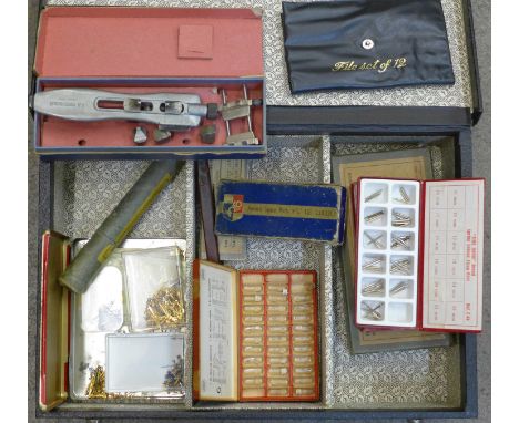 A collection of watch tools including a Kleiner lathe, a universal key for watch backs, hands, strap bars, pin wire, etc.