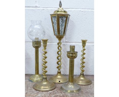 A pair of brass barleytwist candlesticks, two brass lamps and one other brass candlestick