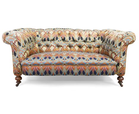 A Victorian mahogany chesterfield sofa, last quarter 19th century, upholstered in a Liberty button back fabric, on turned fee