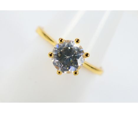 A yellow metal ring presumed gold set with a central clear stone, size R, boxed 2.3g