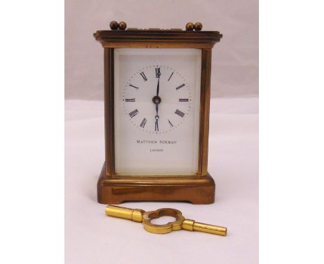 Matthew Norman brass carriage clock of customary form, white enamel dial and Roman numerals, to include key, 10cm (h)
