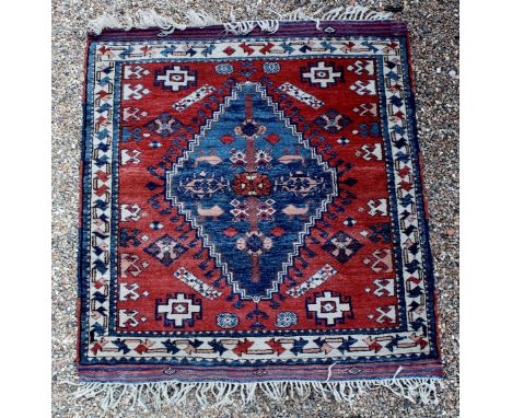 A small rug with plaited fringe to ends, three borders, central beige border, arrow pattern, ochre ground, central blue diamo