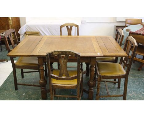 A vintage oak dining table with pull out exterior, on heavy turned legs with a 'x' stretcher, together with four associated d