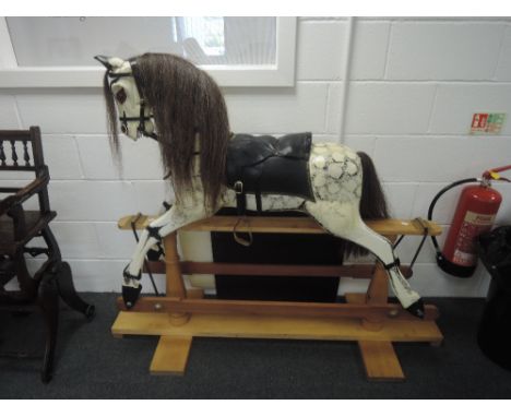 A mid 20th century traditional style rocking horse having horse hair mane and tail on pine swing action base