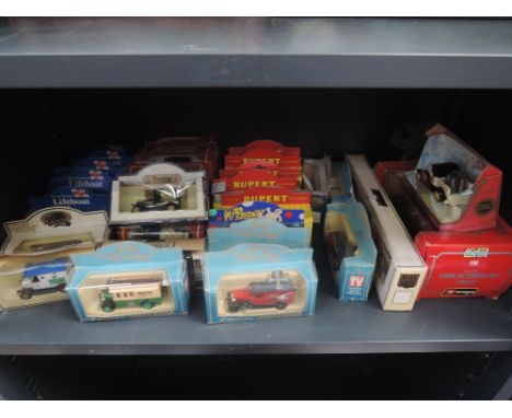 A shelf of mixed die-cast including Lledo Noels House Party, all in window boxes