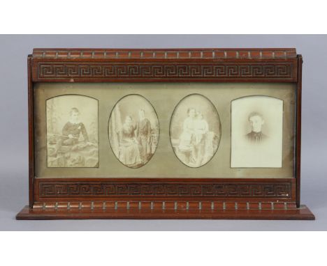 A late 19th/early 20th century carved mahogany table standing photograph frame, 54cm wide x 31cm high, inset with four cabine