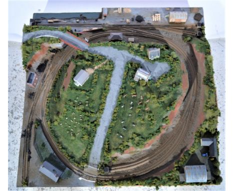 N gauge railway layout, mounted on wooden board, it comes with a circle of track, engine sheds, trackside buildings and anima