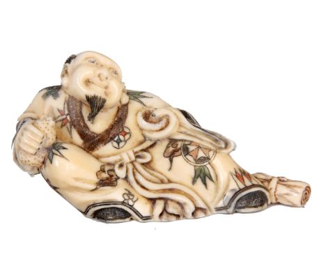 A FINELY CARVED AND ENGRAVED JAPANESE IVORY NETSUKE  OF AN ELDER MAN signed to the base 7cm wide 4cm high.