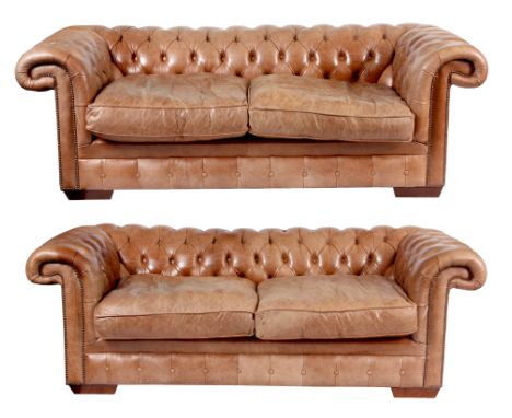 A PAIR OF TAN LEATHER CHESTERFIELD SETTEES with button backs and loose cushion seats.