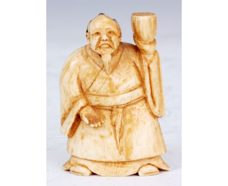 A JAPANESE IVORY NETSUKE of an oriental man in gown.