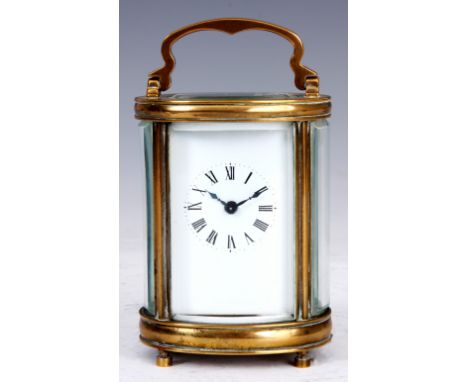 A SMALL FRENCH EARLY 20th CENTURY BRASS OVAL SHAPED CARRIAGE CLOCK the enamel dial with Roman numerals fronting a spring driv