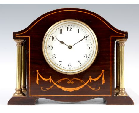 AN EARLY 20th CENTURY FRENCH MAHOGANY CASED MANTEL CLOCK with boxwood inlaid decoration and brass side pillars enclosing a 3.
