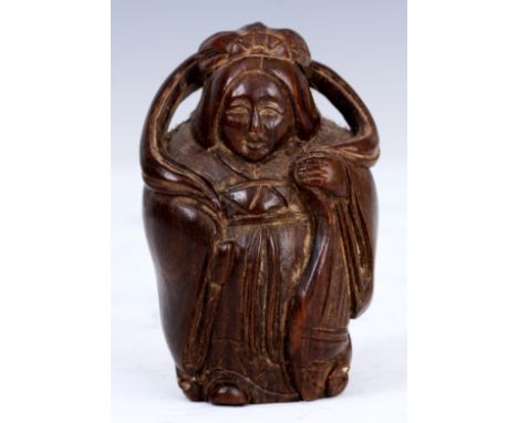 A JAPANESE HARWOOD NETSUKE of a woman in oriental dress.