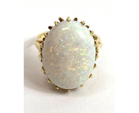 An 18 carat gold opal single stone ring, the oval cabochon measuring approximately 19.5 mm by 15 mm by 7.5 mm deep, finger si