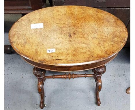 A 19th century walnut sewing oval table on stand, with a carved frame standing on ceramic casters, 73cm high, 62cm long, 44cm