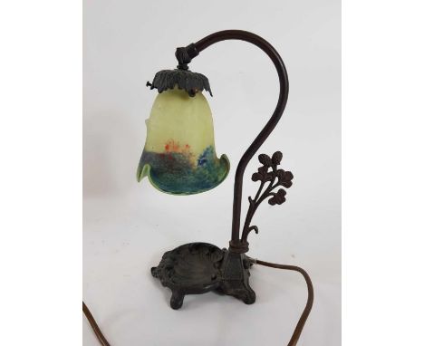 A 20th century Art Nouveau lamp with a glass shade, standing a cast metal base,  31cm high