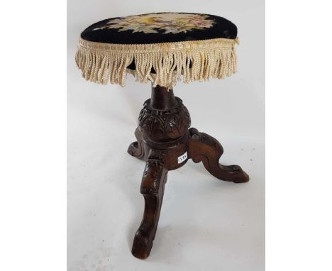 A 19th century stained oak adjustable piano stool, with tapestry seat, and on three outswept legs, decorative carving through