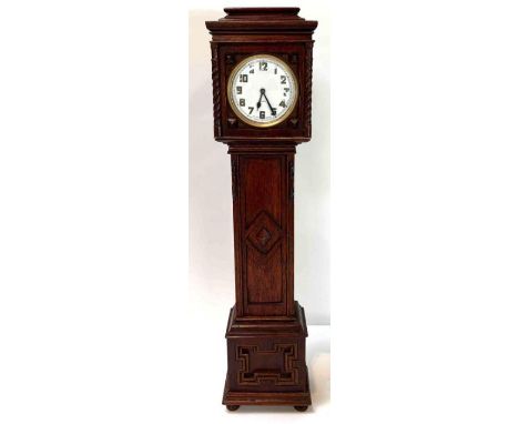 An open face pocket watch with blued steel hands mounted in a miniature wooden long case clock case 38cms high