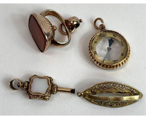 A 19th century vacant carnelian seal fob; a compass fob; a watch key fob; and a filigree pendant