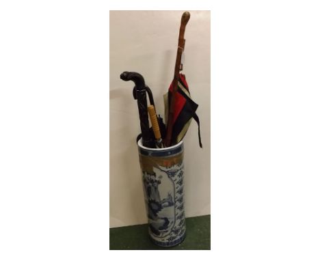 20th century oriental blue and white stick stand with figure decoration, together with a quantity of mixed walking sticks to 