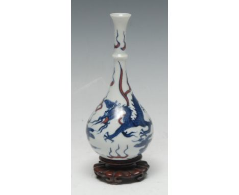 A Chinese porcelain bottle vase, painted in underglaze cobalt blue and manganese red with a ferocious dragon pursuing the fla