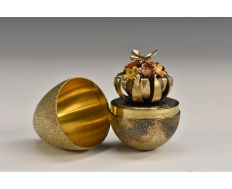 Stuart Devlin (1931 - 2018) - an Elizabeth II silver-gilt and enamel surprise egg, textured overall and enclosing a spray of 